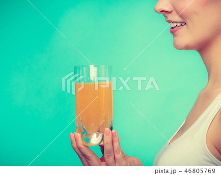 Woman holding glass of orange flavored drink Woman holding glass of orange flavored drink 46805769