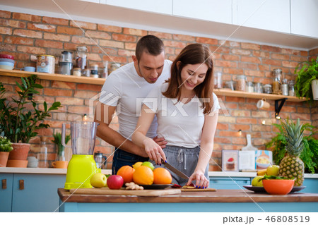 Young couple making smoothie in kitchen Young couple making smoothie in kitchen 46808519