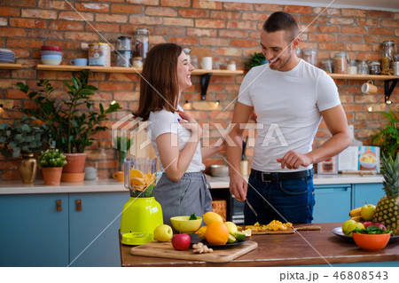 Young couple making smoothie in kitchen Young couple making smoothie in kitchen 46808543