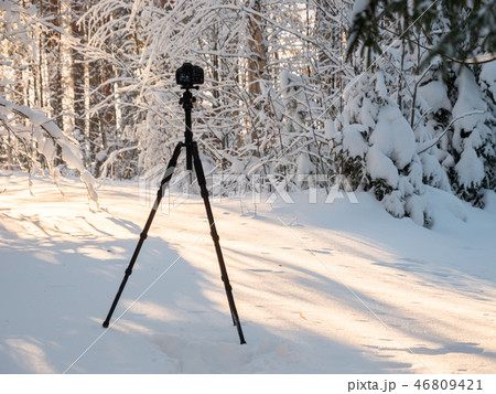 DSLR camera with tripod in snowy landscape 46809421