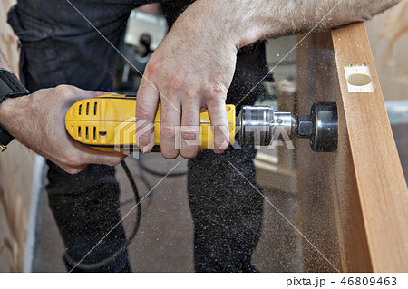 Carpenter drills latch hole of doorlock 46809463