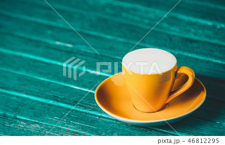 Cup of coffee on wooden table. 46812295