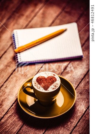 cup of coffee near notebook and pen 46812491