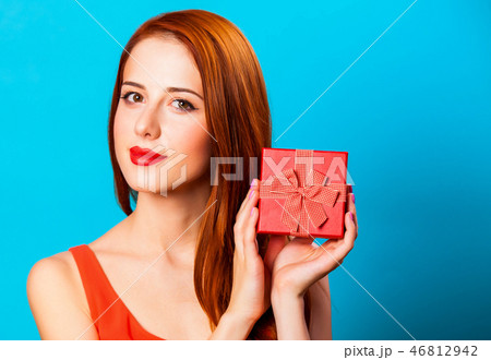 Smiling redhead woman with gift Smiling redhead woman with gift 46812942