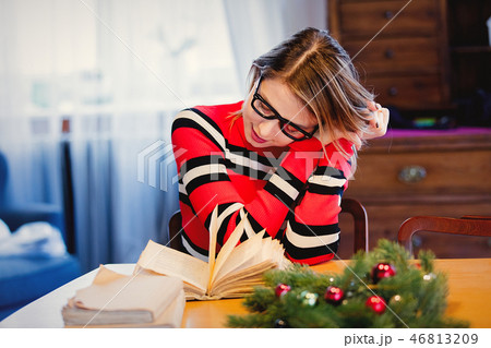 girl in red sweater with books sitting at table girl in red sweater with books sitting at table 46813209