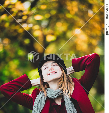woman in red coat and hat have a rest in autum park 46815014