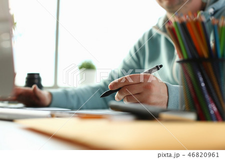 A young designer holds a pen from a tablet in his 46820961