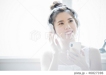 ヘッドホンで音楽を聞く女性 46827396