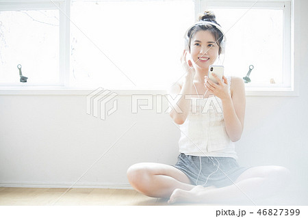 ヘッドホンで音楽を聞く女性 46827399