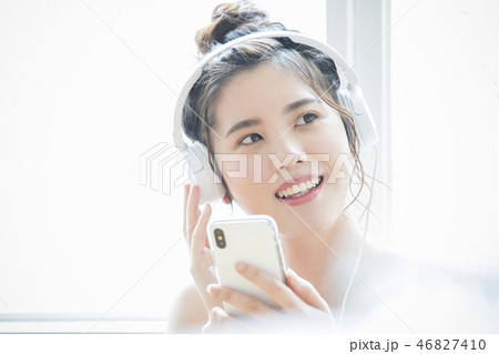 ヘッドホンで音楽を聞く女性 46827410