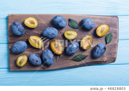 Fresh plums in bowl on wooden table 46828803