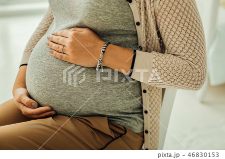 Young woman touching her third-trimester pregnant belly 46830153