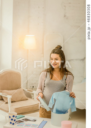 Pregnant woman preparing stylish clothes for her baby Pregnant woman preparing stylish clothes for her baby 46830308