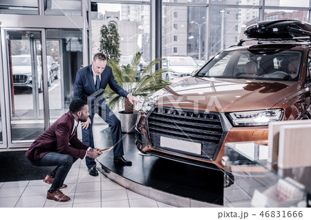 Businessman wearing dark costume buying big family car 46831666