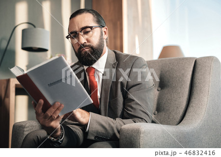 Bearded smart advocate wearing red tie reading administrative law 46832416