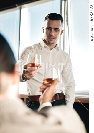 Young handsome man drinking some alcohol with his boss Young handsome man drinking some alcohol with his boss 46832522