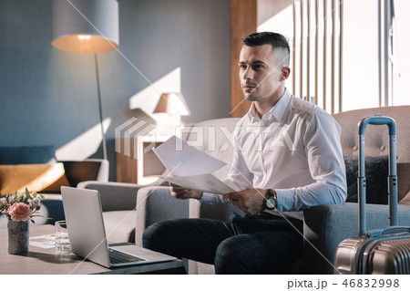Businessman sitting in hotel lobby while having business trip Businessman sitting in hotel lobby while having business trip 46832998