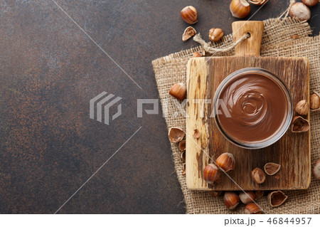 Chocolate spread with hazelnuts on brown countertop Chocolate spread with hazelnuts on brown countertop 46844957