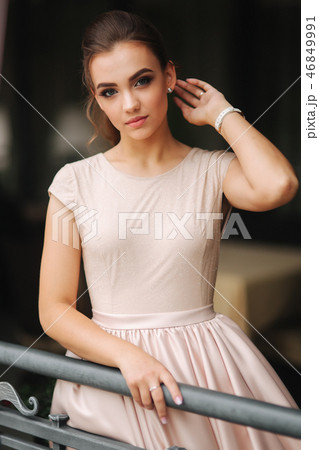 Elegant brunette lady stand on luxury balcony and smile. Fashion hairstyle and makeup Elegant brunette lady stand on luxury balcony and smile. Fashion hairstyle and makeup 46849991