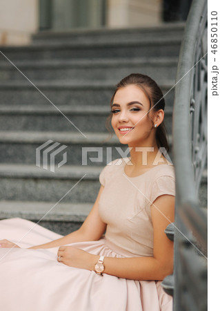 Fashion model sits on the stairs by the hotel. Beautiful lady with modern hairstyle Fashion model sits on the stairs by the hotel. Beautiful lady with modern hairstyle 46850110