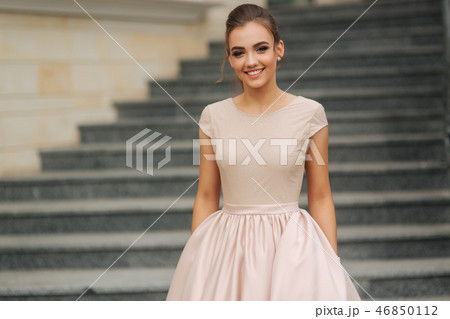 Elegant brunette stand on stairs by the hotel. Fashion model in evening dress 46850112