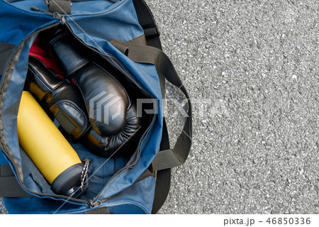 Sports bag and boxing gloves with water at the asphalt background Sports bag and boxing gloves with water at the asphalt background 46850336