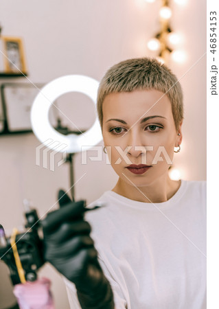 Female master with short hair and big eyes observing details 46854153