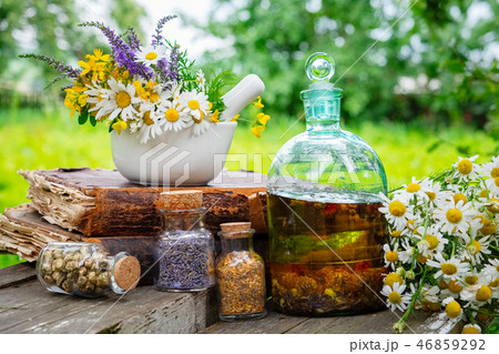Mortar of herbs, essential oil bottle, old book. Mortar of herbs, essential oil bottle, old book. 46859292