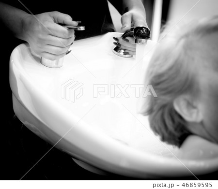 Hairdresser washing a clients head Hairdresser washing a clients head 46859595