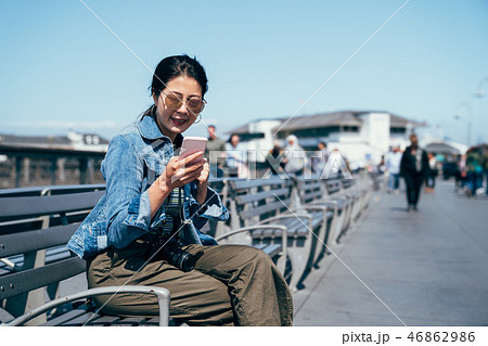 woman using mobile on bench chair 46862986