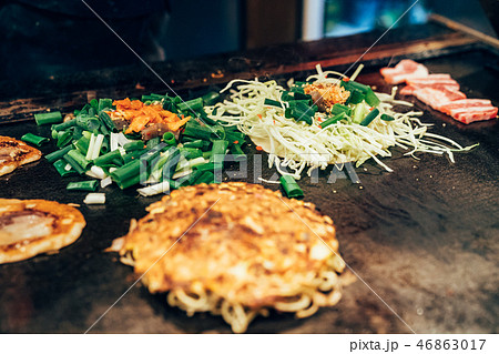 chef adding green onion vegetable in okonomiyaki chef adding green onion vegetable in okonomiyaki 46863017