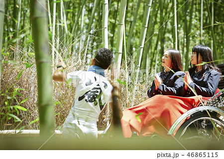 竹林越しに見える人力車に乗る二人の女子高生 46865115