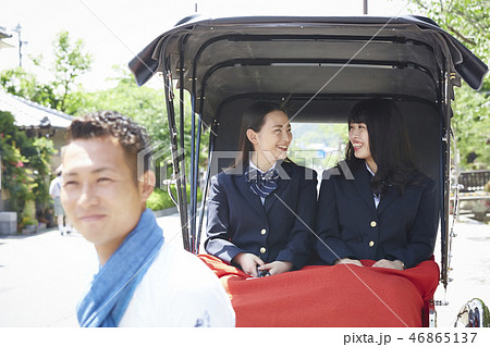 通りで人力車に乗る二人の女子高生 46865137