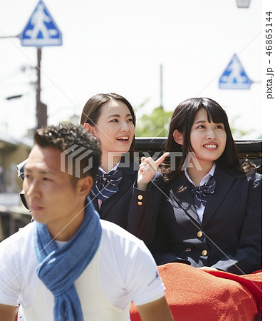 通りで人力車に乗る二人の女子高生 46865144