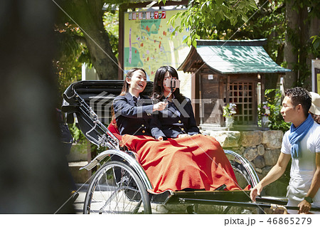 観光案内図の前で停車する人力車に乗った二人の女子高生 46865279