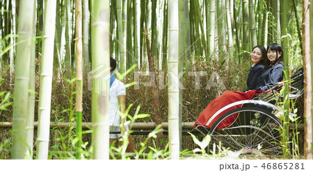竹林越しに見える人力車に乗る二人の女子高生 46865281