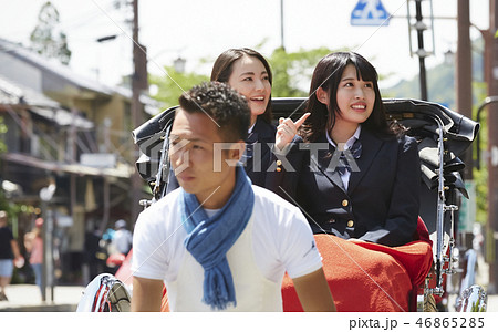 通りで人力車に乗る二人の女子高生 46865285