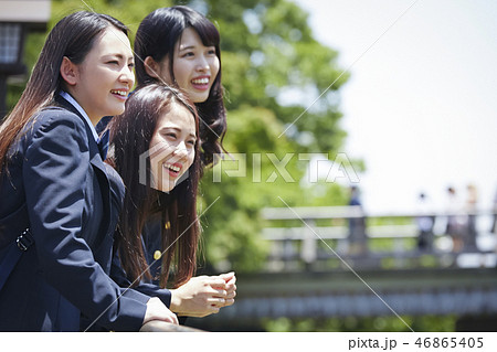 渡月橋を背景に身を乗り出す三人の女子高生の写真素材