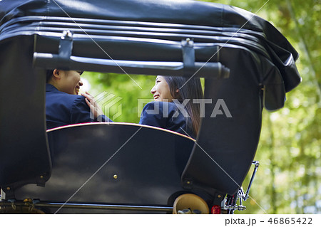 竹林で人力車に乗る二人の女子高生の背中の写真素材