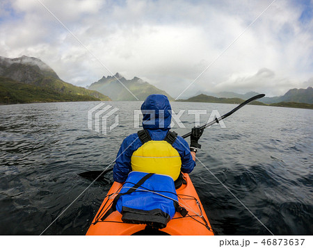 Photo from back of tourist with paddle on canoe floating 46873637