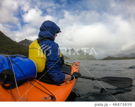 Photo from side of female tourist with paddle on canoe floating 46873639