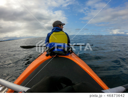 Photo from back of female tourist with paddle on canoe floating Photo from back of female tourist with paddle on canoe floating 46873642