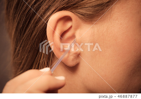 Woman cleaning ear with cotton swabs closeup Woman cleaning ear with cotton swabs closeup 46887877