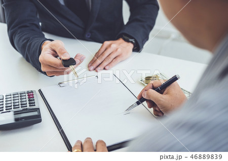 Salesman send key to customer after man signing car document con 46889839