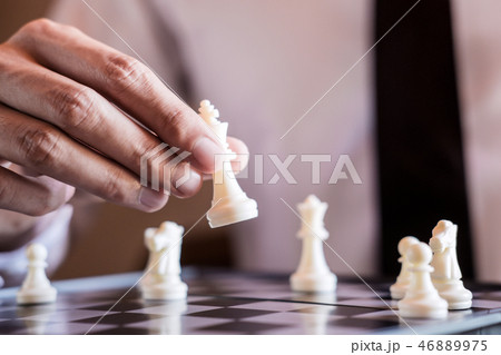 Hand of confident businessman use king chess piece white playing Hand of confident businessman use king chess piece white playing 46889975