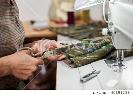 Seamstress working on modern electrical sewing machine making exclusive garments in fashion studio. 46891258