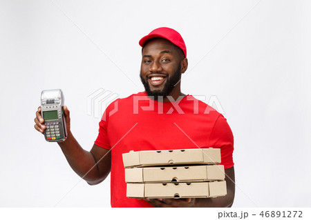 Happy young African American delivery man holding up an electronic card payment machine and delivery 46891272
