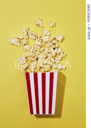 Full of popcorn in classic striped box on color ba Full of popcorn in classic striped box on color ba 46891996