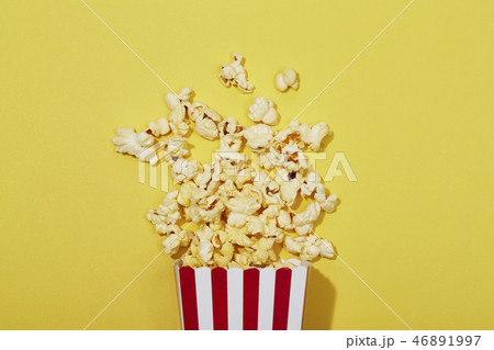 Full of popcorn in classic striped box on color ba Full of popcorn in classic striped box on color ba 46891997