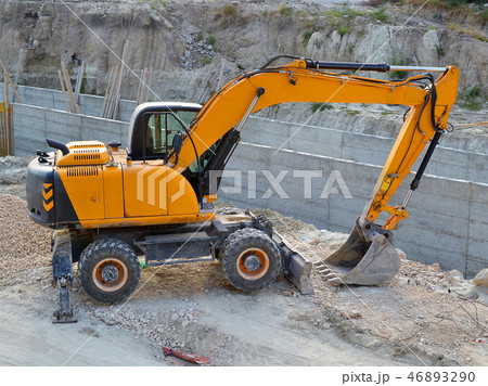 Yellow excavator in the construction pit 46893290